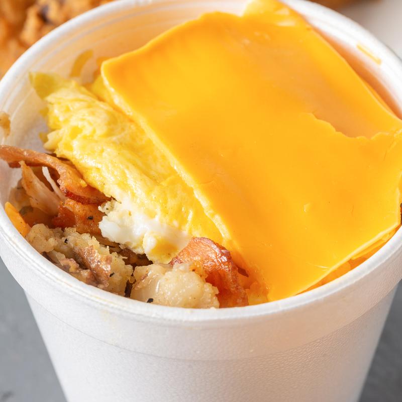 Breakfast bowl with eggs, potatoes, bacon and melted cheese